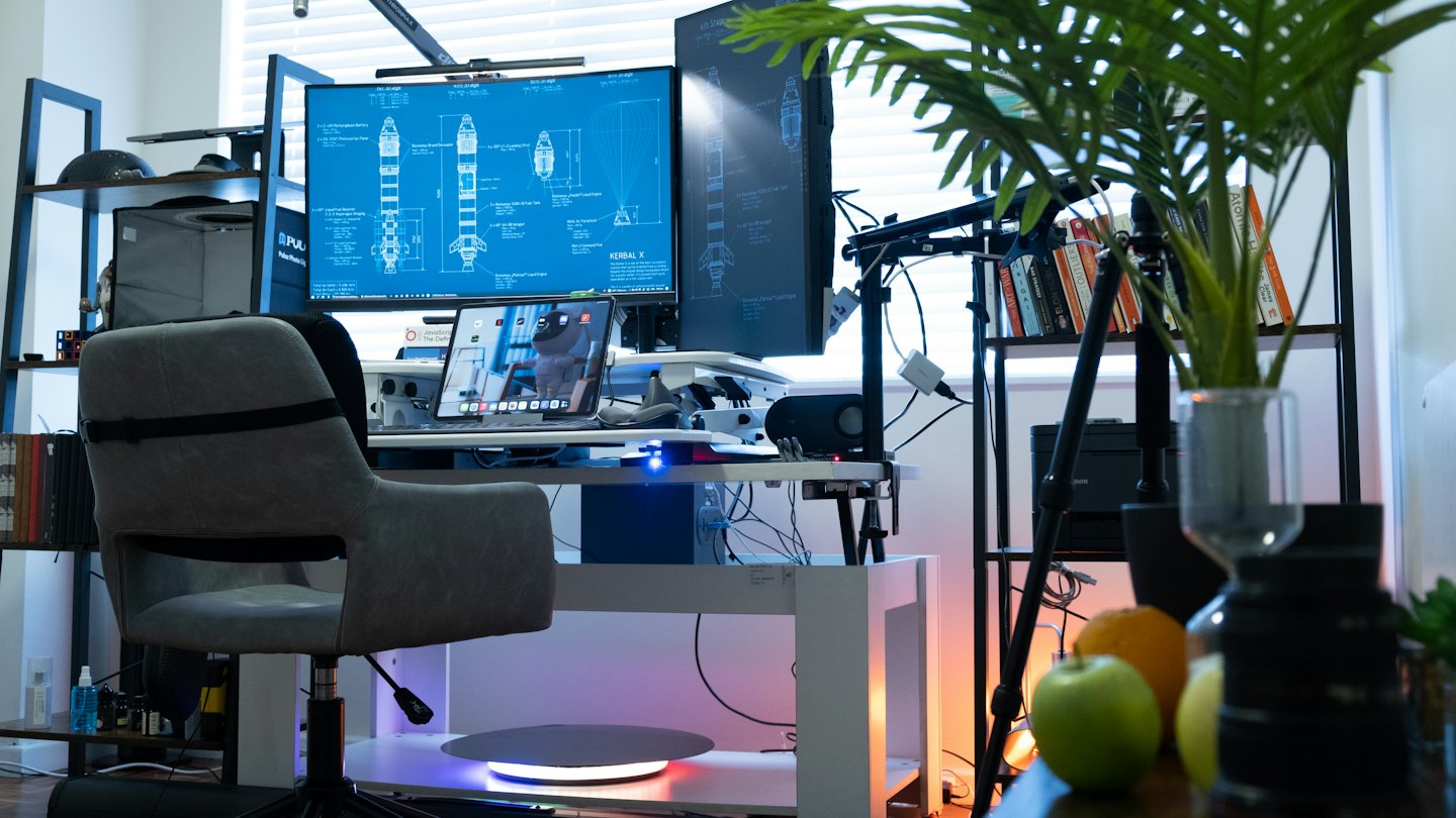 Una scrivania da ufficio in casa ben organizzata con doppio monitor che mostra progetti di razzi.